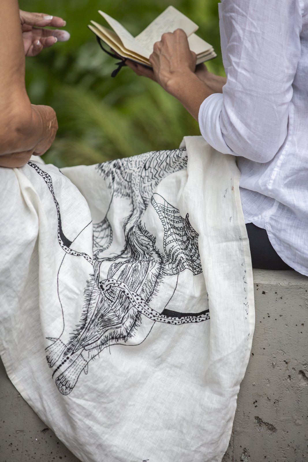 Linen still at the drawing stage, sketchbook open behind it