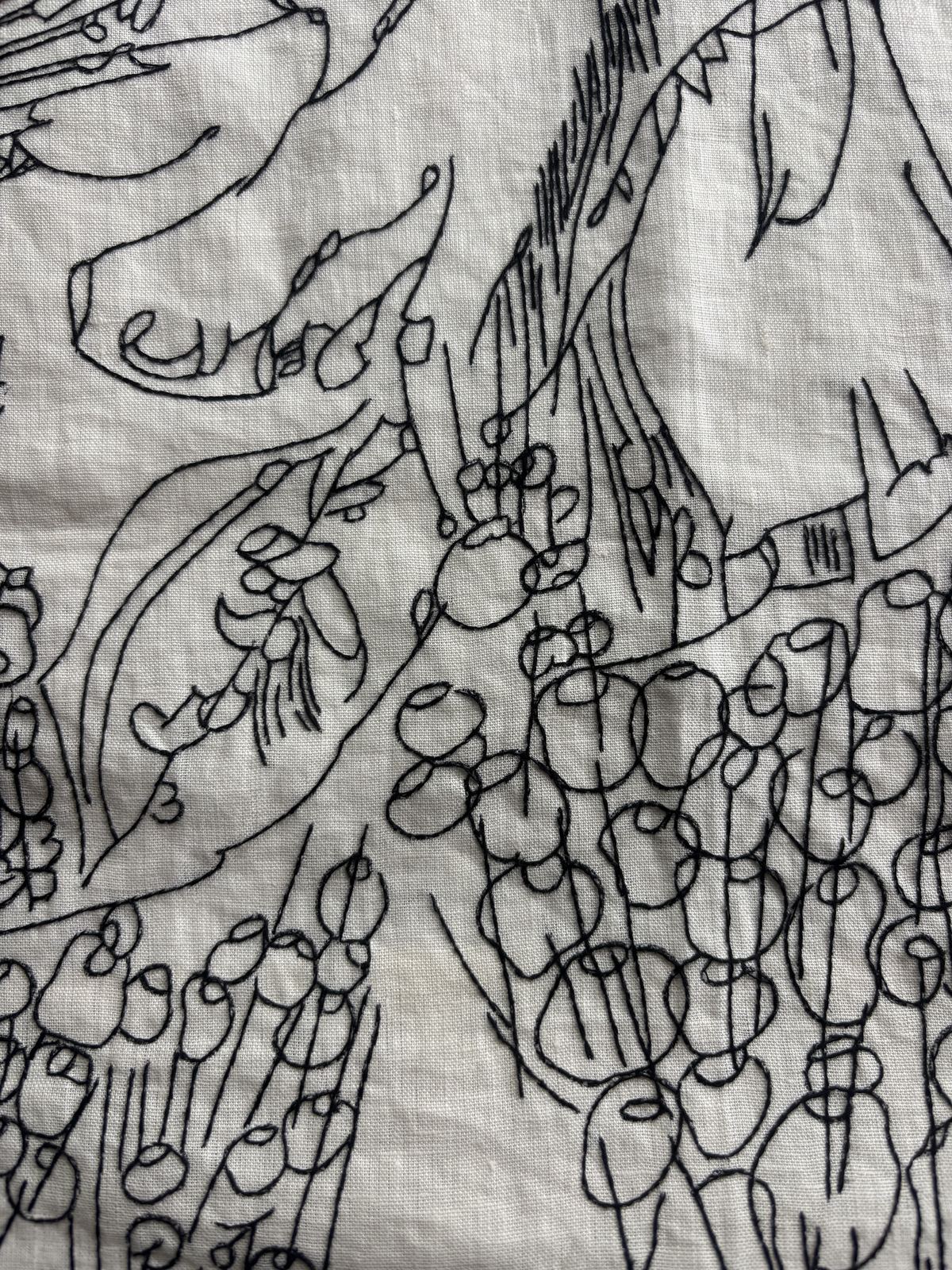 Close detail of black-thread stitching, dense hatching
