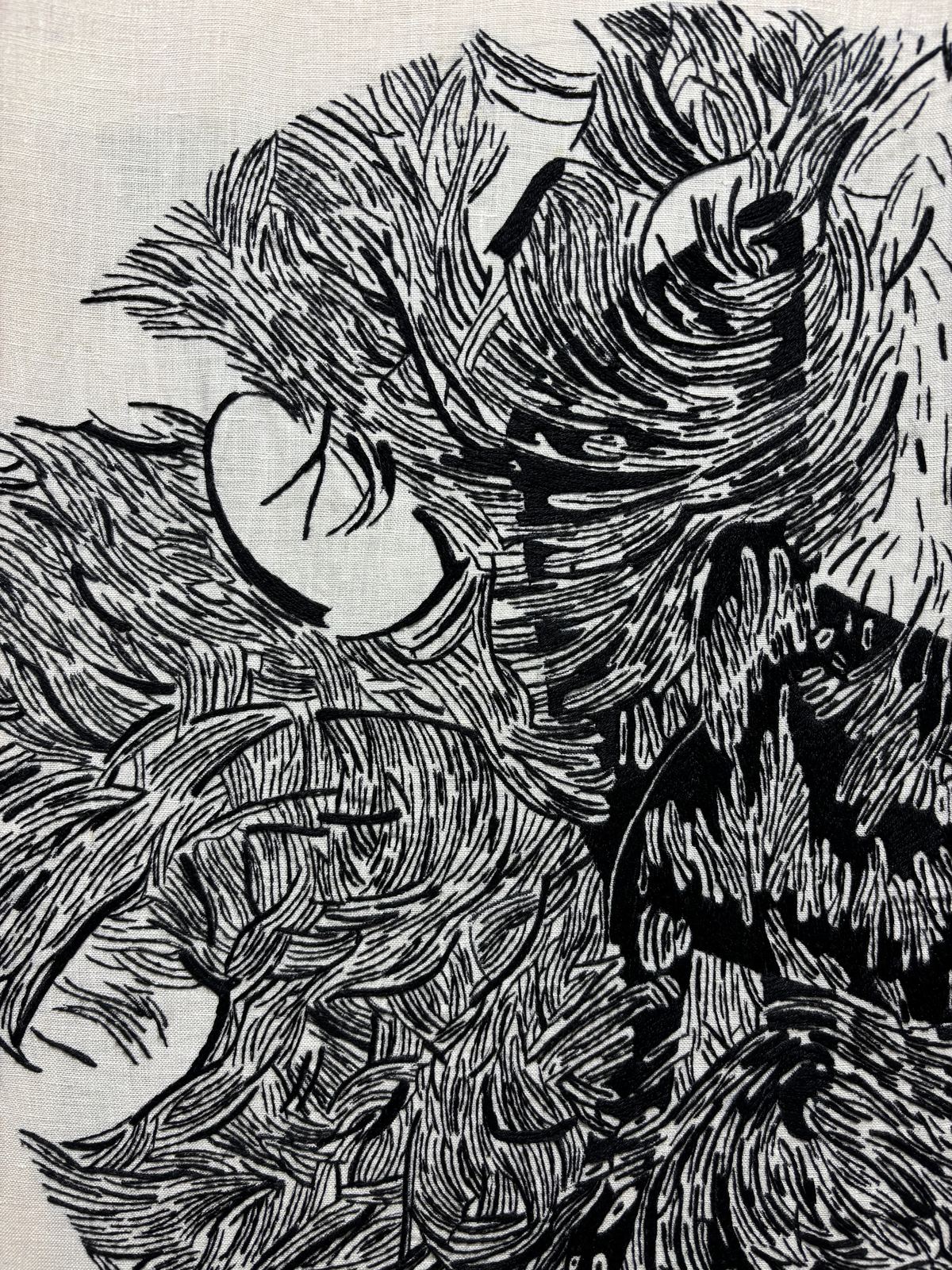 Close detail of swirling feather stitching with an eye-like form